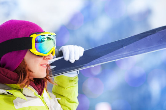 Close-up of happy woman in mask holding ski