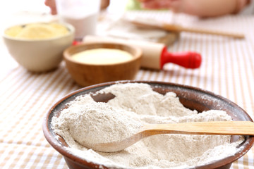 Young woman prepares dough on table close up