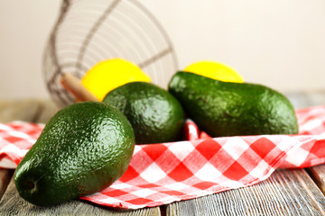 Avocado with lemons on napkin on wooden table close up