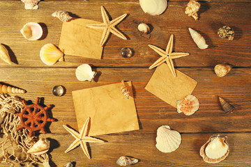 Card blanks with sea stars and shells on wooden background