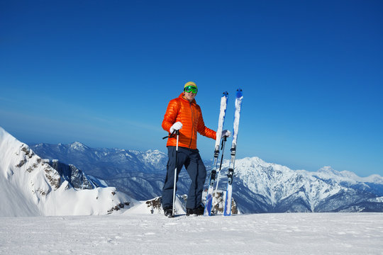 Man in ski mask stands and beautiful mountain view