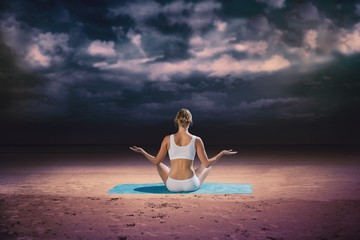Composite image of fit woman sitting in lotus pose