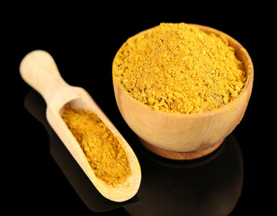 Curry in wooden bowl, isolated on black