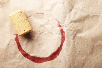 Wine stain and cork on crumpled paper background