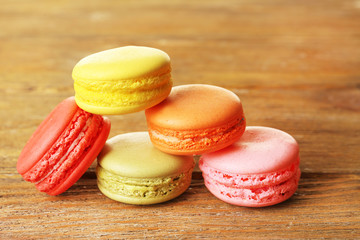 Tasty colorful macaroons on rustic wooden planks background