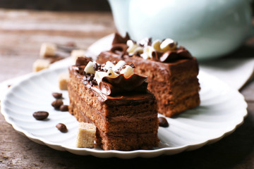 Fototapeta na wymiar Tasty piece of chocolate cake with lump sugar and coffee beans