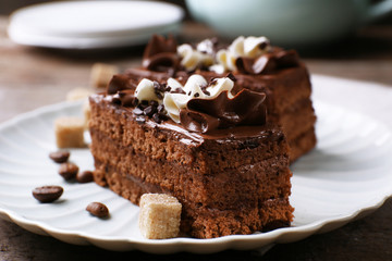 Tasty piece of chocolate cake with lump sugar and coffee beans