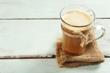 Glass cup of cocoa on color wooden planks background