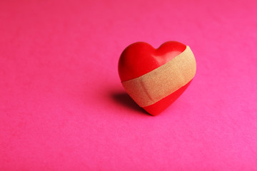 Heart with plaster on colorful background