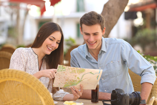 Couple tourists consulting a guide in a restaurant