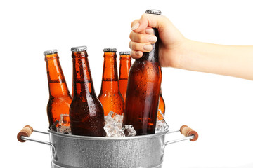 Female hand taking bottle of beer from bucket isolated on white © Africa Studio