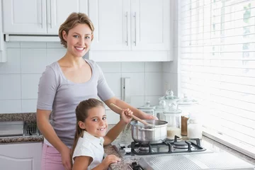 Crédence de cuisine en verre imprimé Cuisinier Mother and daughter cooking together
