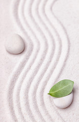 Zen garden with a wave lines in the sand with relaxing white sto