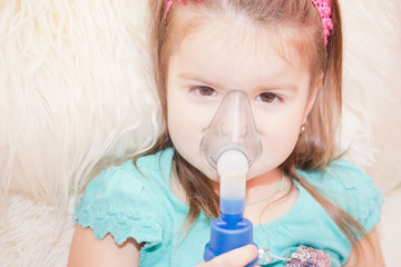 Little girl using an inhaler indoors