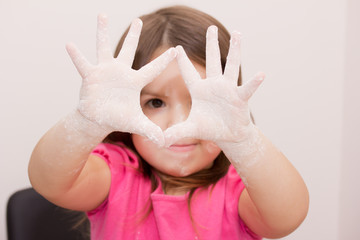 little girl play with flour