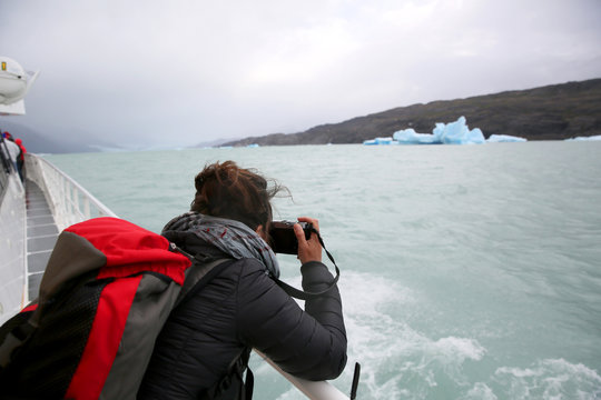 Tourist on boat taking picture of an Iceberg, Argentino Lake