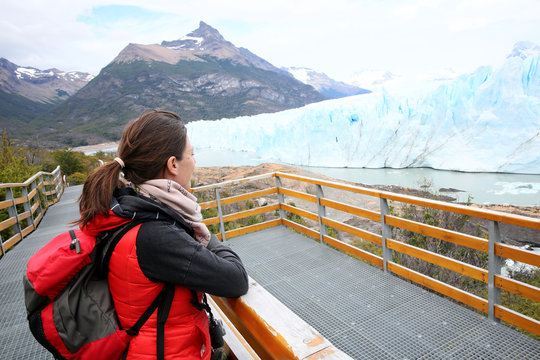 Tourist standing on footbridge in front of Perito Moreno Glacier