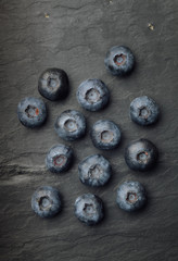 A bunch of delicious blueberries on a dark vintage slate of tile