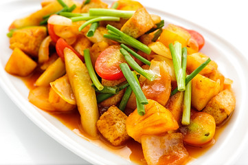 Fried vegetables with red sauce on white plate