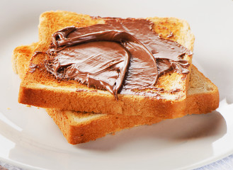 Bread with chocolate spread on  white plate