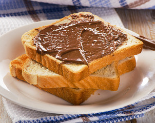 Toast with chocolate spread on  white plate