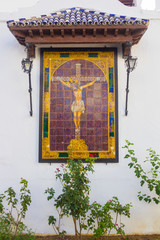 small altar with a Christ Andalusian tiles on a white wall