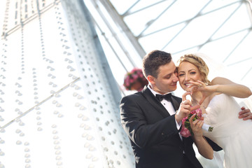 groom and bride doing love sign with their hands