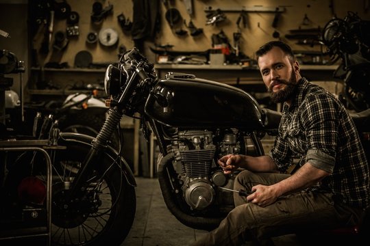 Mechanic building vintage style cafe-racer motorcycle 