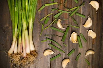 Spring onion and garlic on wooden background