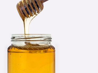 Honey isolated on white. Jar, honey dipper.