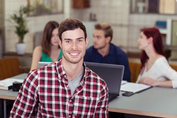 mann am arbeitsplatz mit team im hintergrund