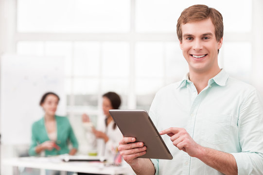 Young smiling businessman using tablet computer