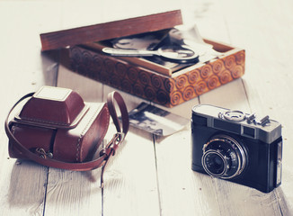 Old camera with bag and wood box with photos