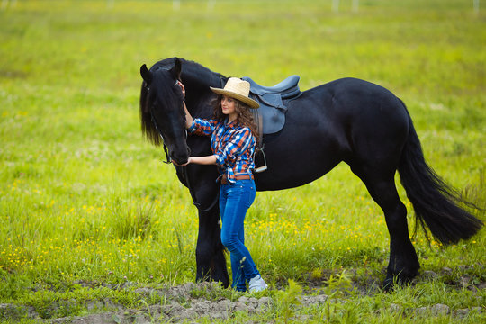 Young beautiful girl with frisian horse