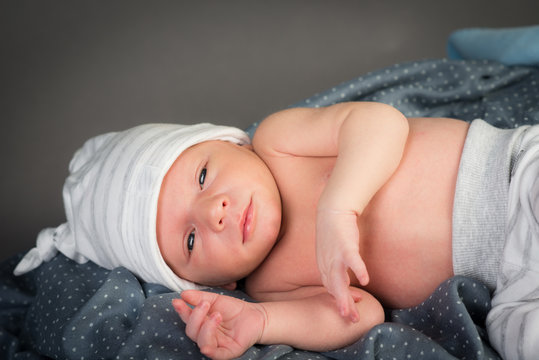 beautiful newborn baby boy isolated on gray a background