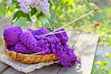 Balls of yarn and knitting in a basket in the garden