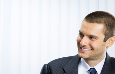 Happy smiling young businessman, at office