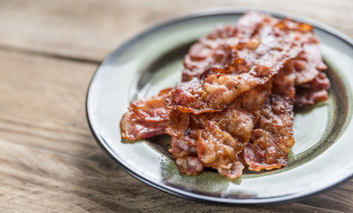 Stack of fried bacon strips on the plate