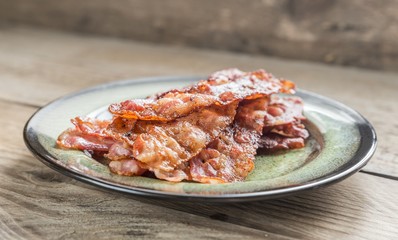 Stack of fried bacon strips on the plate