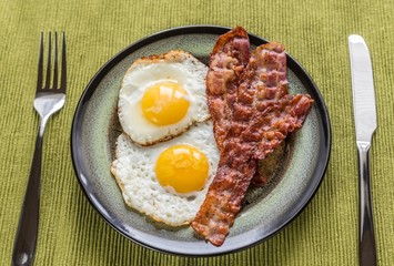 Portion of fried eggs with bacon