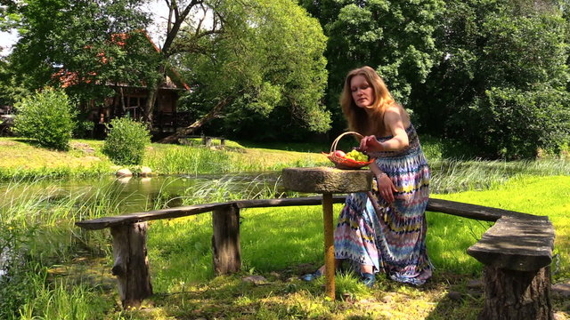 happy pregnant woman have picnic on bench near river water