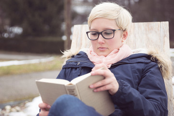 Junge Frau liest konzentriert in einem Buch
