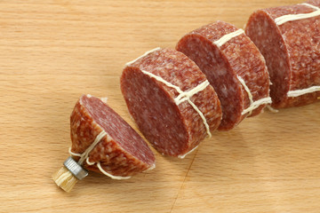 cut sausage  braided with white strand on a cutting board