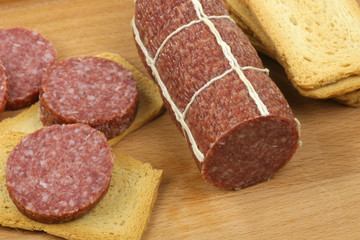 sausage slices and toast on a wooden cutting board