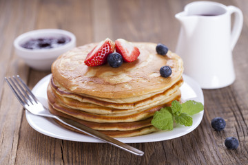 Delicious sweet American pancakes on a plate with fresh fruits