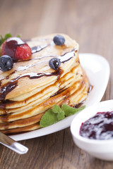 Delicious sweet American pancakes on a plate with fresh fruits