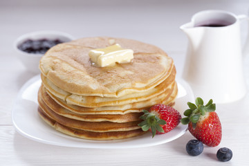Delicious sweet American pancakes on a plate with fresh fruits