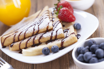 Delicious sweet French pancakes on a plate with fresh fruits