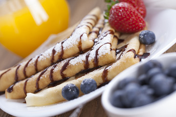 Delicious sweet French pancakes on a plate with fresh fruits