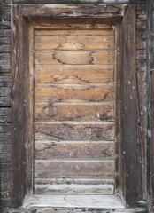 old cabin doorway with falling snow